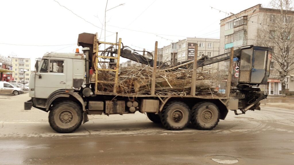Вывоз деревьев с участка: КамАЗ с манипулятором везёт стволы и ветки